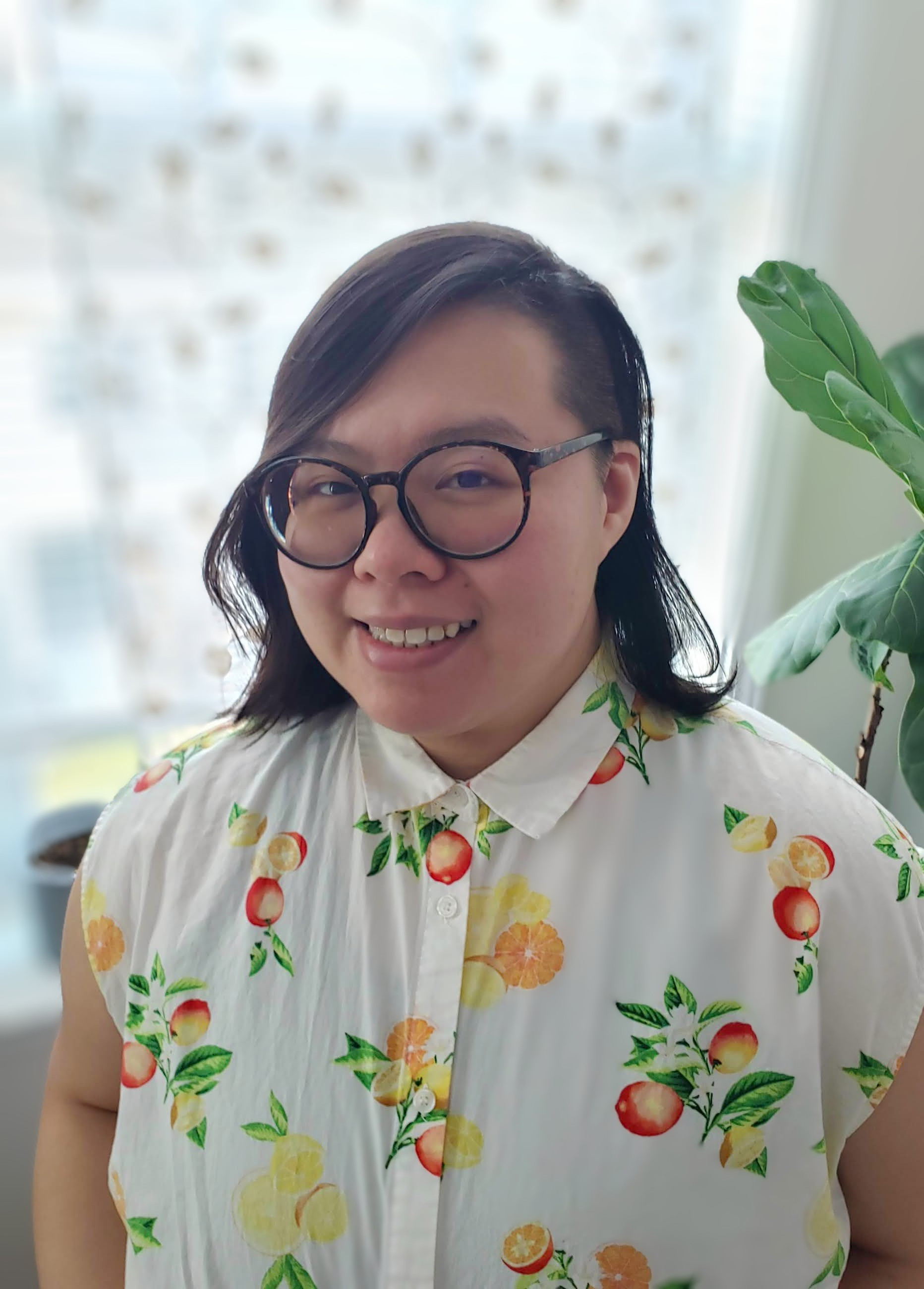 photo of ren lee,a light-skin chinese therapist, wearing glasses and a button down shirt in front of a bright window